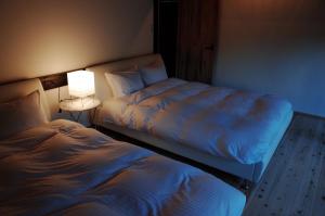 two beds in a room with a lamp next to it at Goto - House / Vacation STAY 47376 in Goto