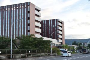 a white van driving down a road in front of a building at Motel inn Minami Otaru / Vacation STAY 50438 in Otaru