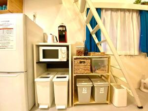 a small kitchen with a microwave and trash cans at i home Tsubogawa - Vacation STAY 16570v in Naha