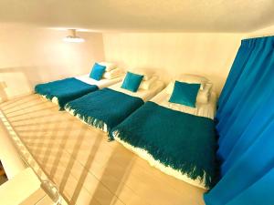 three beds in a room with blue pillows at i home Tsubogawa - Vacation STAY 16570v in Naha