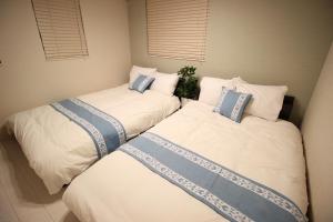 two twin beds in a small room with windows at HOPE VILLA Onna-son - Vacation STAY 52847 in Inbu