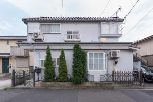ein weißes Haus mit Bäumen davor in der Unterkunft Setagaya-ku - House / Vacation STAY 4789 in Kokuryō