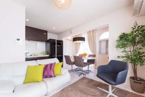 ein Wohnzimmer mit einem weißen Sofa und einem Esszimmer in der Unterkunft Setagaya-ku - House / Vacation STAY 4789 in Kokuryō