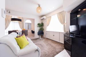 ein Wohnzimmer mit einem weißen Sofa und einem Fernseher in der Unterkunft Setagaya-ku - House / Vacation STAY 4789 in Kokuryō