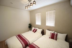 two beds in a bedroom with white and red pillows at HOPE VILLA Onna-son - Vacation STAY 52854 in Inbu