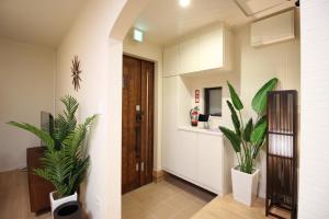 a hallway with two potted plants in a room at HOPE VILLA Onna-son - Vacation STAY 52850 in Inbu