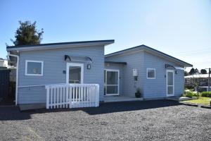 a small house with a white fence in a driveway at Trailblazer Studios in Waihi