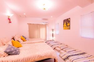 two twin beds in a bedroom with white walls at Kunigami-gun - House / Vacation STAY 53153 in Atsutabaru