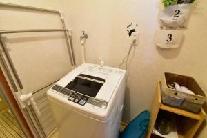 a washing machine sitting in a corner of a room at Mori building / Vacation STAY 49788 in Takamatsu +8 photos