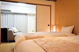 zwei Betten in einem Hotelzimmer mit Fenster in der Unterkunft Scarl Matsunawa / Vacation STAY 49770 in Takamatsu