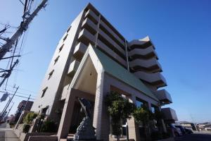 ein großes Gebäude mit einer Statue davor in der Unterkunft Scarl Matsunawa / Vacation STAY 49770 in Takamatsu