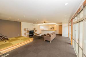 a large room with a bed and a couch at Tancha Detached house / Vacation STAY 50245 in Motobu