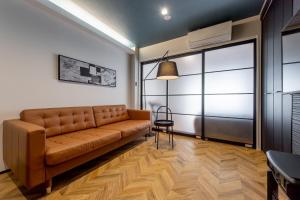 a living room with a brown couch and a table at Oyado Urushi / Vacation STAY 50682 in Nagasaki