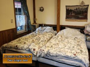 a bed with a comforter on it in a bedroom at Eniwa - House - Vacation STAY 18354 in Eniwa