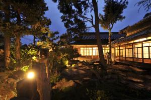 a building with a light in a garden at night at Kanakuraen / Vacation STAY 5125 in Marugame