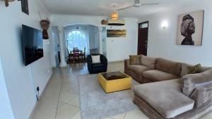 ein Wohnzimmer mit Sofa und Tisch in der Unterkunft Ary Homestay - On 5th Avenue in Nyali