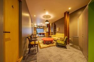 un soggiorno con un divano, un tavolo e delle sedie di Linden Haus BEPPU - Vacation STAY 54769 a Beppu