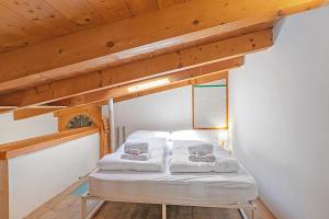 una cama en una habitación con techo de madera en Nido dell'Usignolo - Happy Rentals, en Riva del Garda