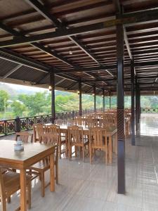 an empty restaurant with wooden tables and chairs at Nusantara Hotel Sembalun in Sembalun Lawang
