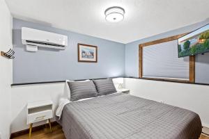 una camera con letto e condizionatore d'aria di Sister Sunset - #1 Downtown Location this Fall! Hot Tub, Dogs Welcome! a Sister Bay