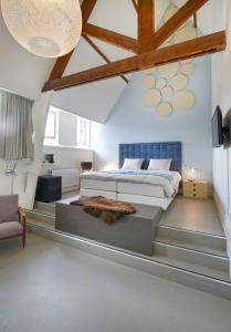 a bedroom with a king sized bed in a attic at Kloosterhotel de Soete Moeder in Den Bosch