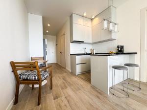 een keuken met witte kasten en een tafel en stoelen bij Bamboo Beach Tsikhisdziri in Tsikhisdziri