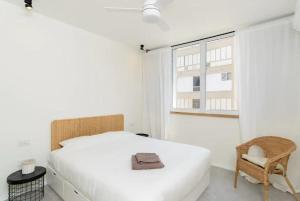 ネタニヤにあるLuxury 3BR with Sea Views in Netanya By Barnesのベッドと椅子と窓のある寝室