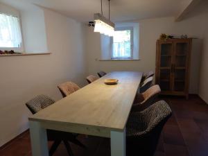a dining room with a wooden table and chairs at Ferienwohnungen Alte Schmiede in Wallenfels
