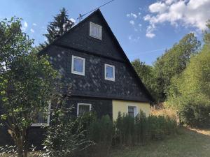 a black and yellow house with a black roof at Ferienwohnungen Alte Schmiede in Wallenfels