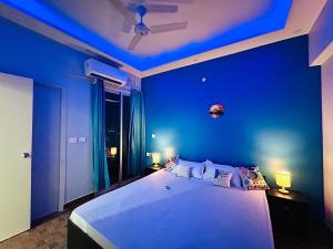 a bedroom with a large white bed with blue walls at SkyVista - City View Apartment 