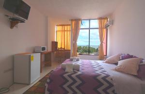 a bedroom with a large bed and a window at Hostal Tongo Reef in Puerto Baquerizo Moreno