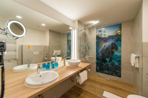 a bathroom with two sinks and a large painting on the wall at Best Western Hotel Wiesbaden in Wiesbaden +67 photos