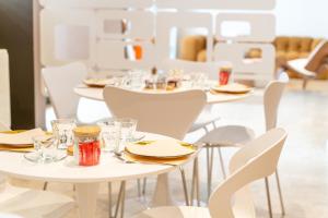 a dining room with white tables and chairs at Hôtel Comté de Nice in Beaulieu-sur-Mer