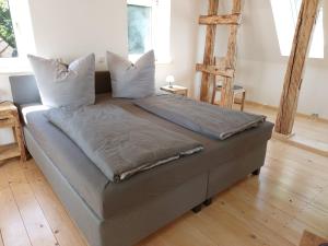 a large bed in a room with wooden floors at Ferienwohnungen Alte Schmiede in Wallenfels