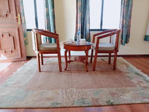 deux chaises et une table dans une pièce dans l'établissement Hotel Norbu Sangpo, à Katmandou