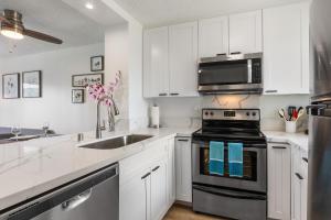 a kitchen with white cabinets and a stove top oven at 01 FREE Parking 10 min beach 2br-Waikiki Ala Moana in Honolulu