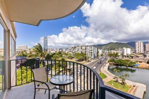 a balcony with a table and chairs and a view of a city at 01 FREE Parking 10 min beach 2br-Waikiki Ala Moana in Honolulu