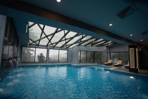 Una gran piscina con sillas en un edificio. en Doubletree By Hilton Nathiagali, en Nathia Gali