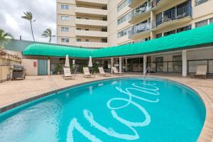 a large swimming pool in the courtyard of a hotel at 01 FREE Parking 10 min beach 2br-Waikiki Ala Moana in Honolulu