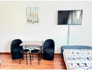 ein Zimmer mit einem Tisch, zwei Stühlen und einem Fernseher in der Unterkunft Julus in Łeba