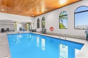 a swimming pool with a wooden ceiling and windows at Quality Inn & Suites Sunport Airport Albuquerque in Albuquerque