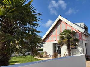 a house with palm trees in front of it at La morinière in Carantec