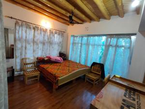 列城Eco Friendly Guest House的一间有一张床和两把椅子的卧室