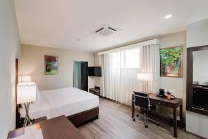 a hotel room with a bed and a desk with a computer at Comfort Inn & Suites Tobago in Tobago Island
