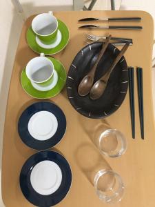 a table with green and black plates and spoons at Utopia Wakamiya 207 / Vacation STAY 5372 in Fukuoka