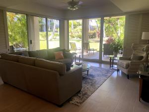 a living room with a couch and chairs and windows at Waikoloa Beach Condo in Waikoloa