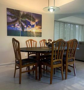 a dining room table and chairs with a table and a painting at Waikoloa Beach Condo in Waikoloa