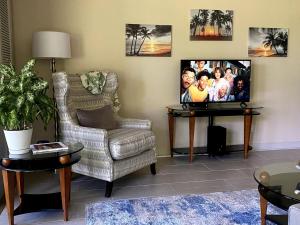 a living room with a chair and a flat screen tv at Waikoloa Beach Condo in Waikoloa