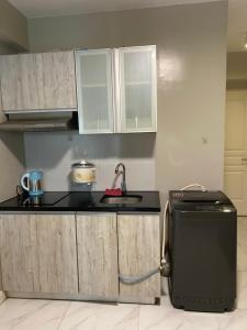 a kitchen with a sink and a refrigerator at Monarch Parksuites in Manila