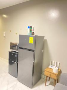 a kitchen with a stainless steel refrigerator and a table at Monarch Parksuites in Manila +3 photos